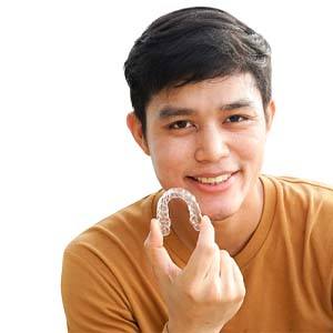 Teenager holding Invisalign in North Naples