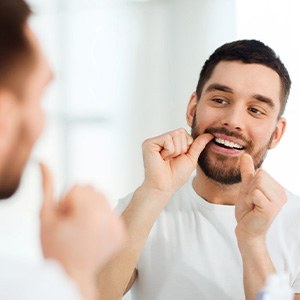 Man flossing his teeth