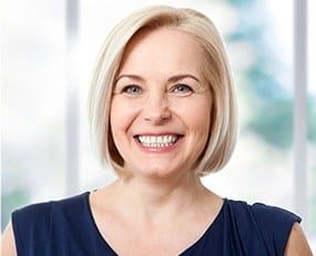 Smiling older woman in dark blue blouse