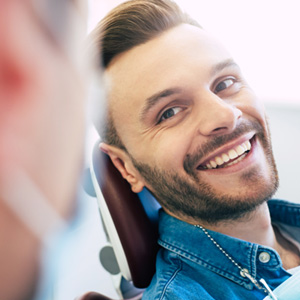 Man smiling at dentist while sitting in treatment chair