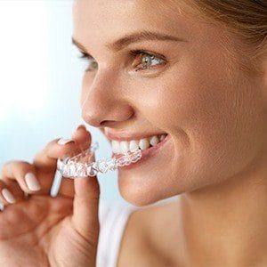 Woman placing Invisalign tray