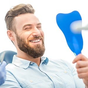 Man looking at smile in mirror