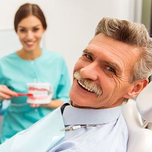 a patient smiling after receiving his dentures in North Naples