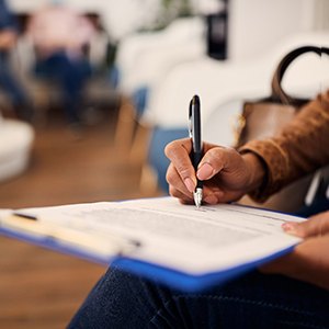 Closeup of patient filling out dental insurance forms