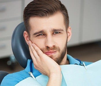 Man in pain holding cheek