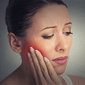 Woman in pain holding jaw
