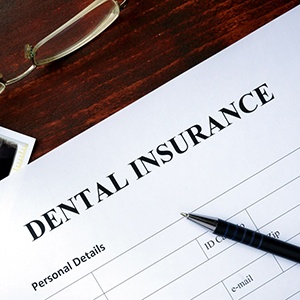 stack of money with dental tools on table