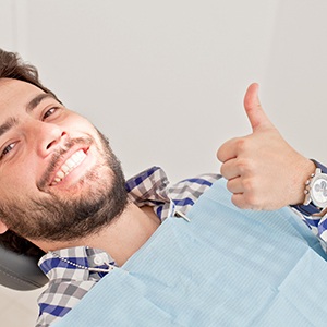 Male dental patient with watch giving thumbs up