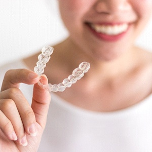 Person holding Invisalign aligner in North Naples