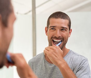 a man brushing his teeth at home