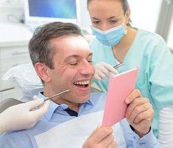 Man looking at smile in mirror