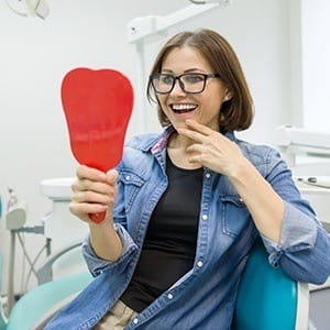 Woman looking at smile in mirror