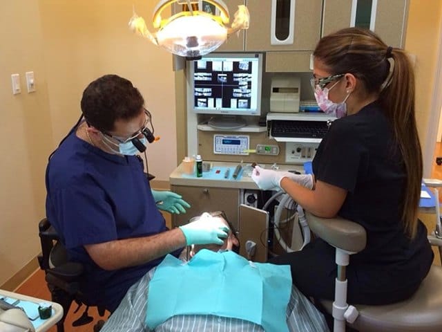 Dentist and team member treating dental patient