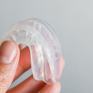 Closeup of patient holding clear aligner