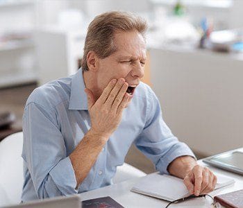 Man holding jaw in pain