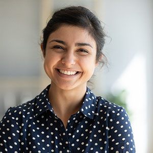 Woman in polka dot shirt smiling at home