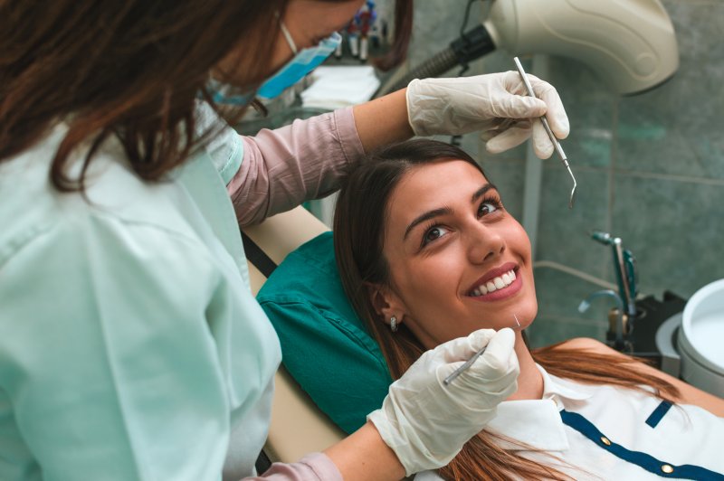 a woman having her teeth checked by the dentist