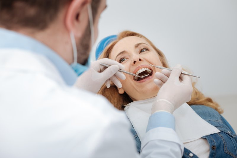 a woman having her teeth checked by her dentist