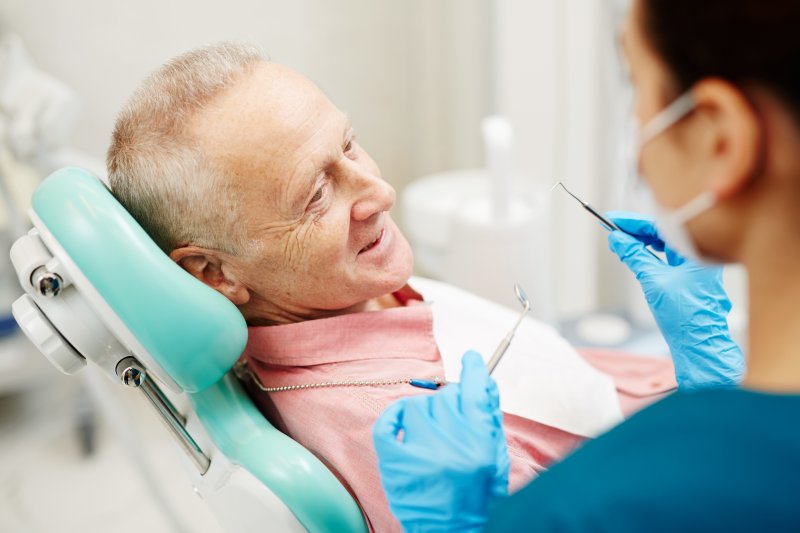 an older gentleman having his teeth checked at the dentist’s office