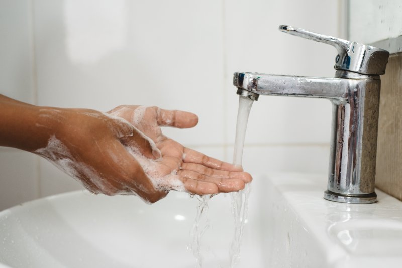 Person washing hands before visiting a dentist in North Naples.