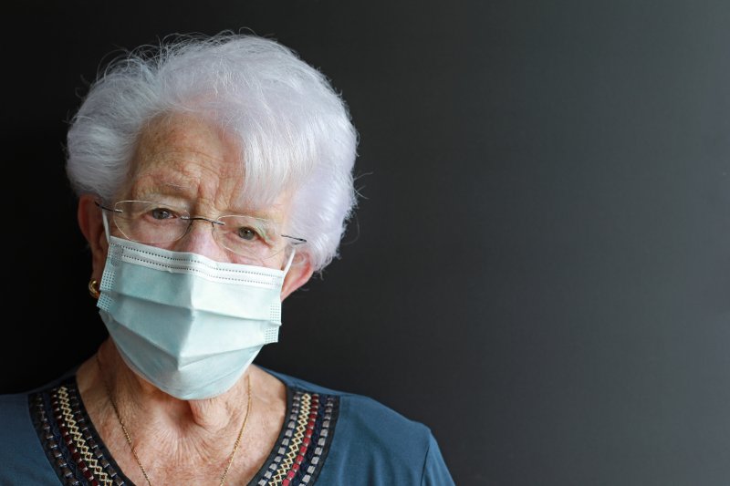 an elderly woman wearing a  face mask and glasses