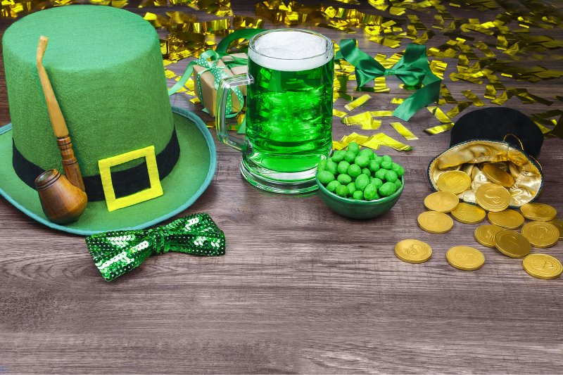 a green top hat, bow tie, pipe, beer, nuts, and a small pot of gold for St. Patrick’s Day 