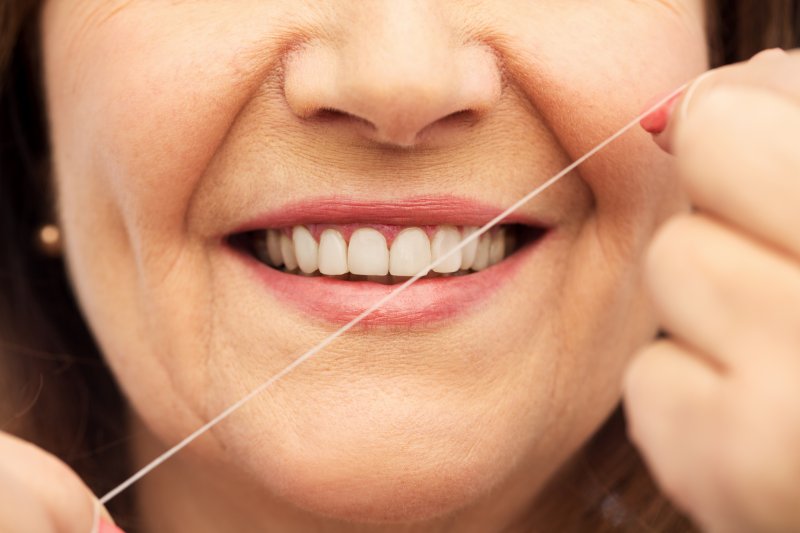 woman flossing with dental implants