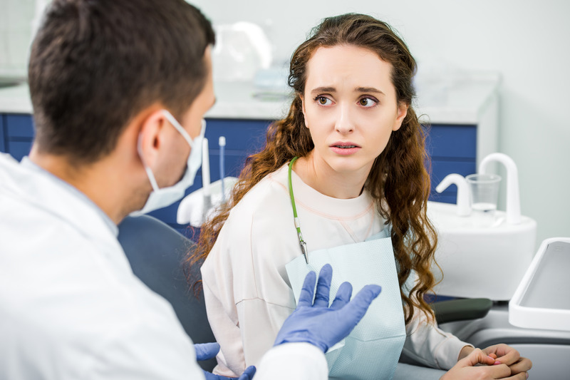 Sad patient talking to dentist about cosmetic dentistry
